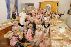 Anamaria Dahinten mit den kleinen Bäckerinnen und Bäckern: Begeisterte und energiegeladene Kinder füllen die Backstube des Pfarrhauses in Mühlbach.