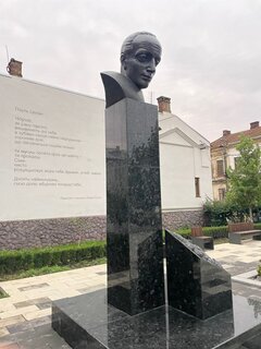 Granitstele mit dem Kopf Celans vor Versen der Todesfuge