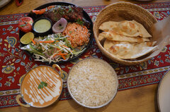 „Butter Chicken“ mit Reis und „Tandoori Chicken Platter“ mit Naan-Brot.